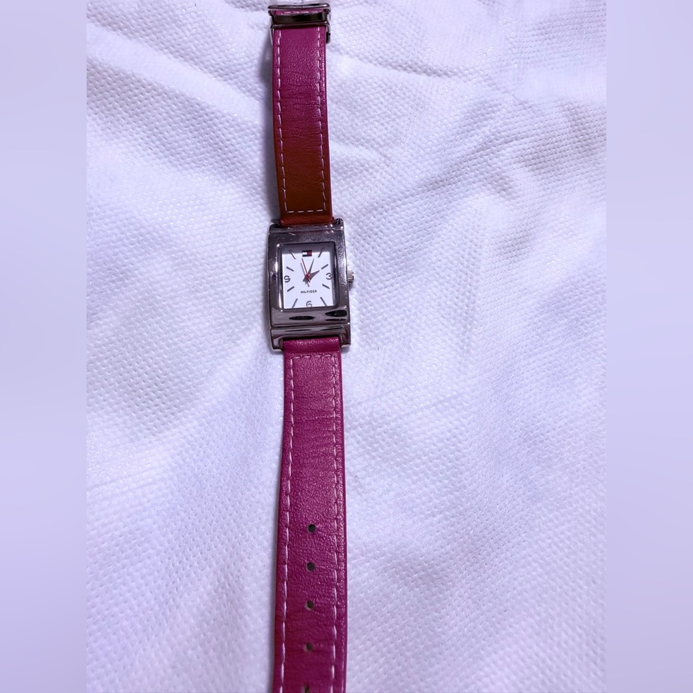 “Tommy Hilfiger wristwatch with interchangeable red and navy blue bands.